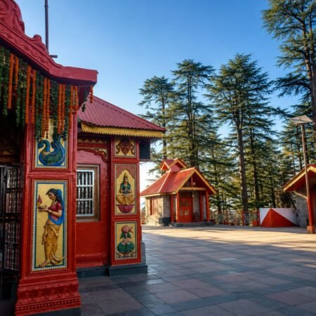 Peaceful courtyard of Jakhoo Temple in Shimla with traditional temple architecture and deodar trees, featured in the Shimla Tour Package from Delhi.