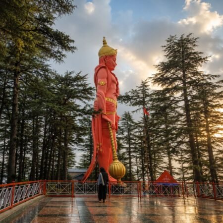 Giant Hanuman statue at Jakhoo Temple in Shimla during golden hour, a popular attraction included in the Shimla Tour Package from Delhi.