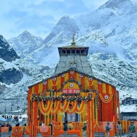 Kedarnath Temple decorated with flowers and garlands against snow-covered Himalayan mountains
