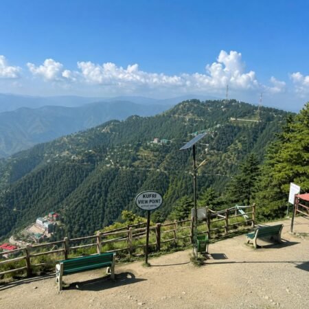 Panoramic view from Kufri Viewpoint overlooking the Himalayan mountains and pine forests, featured in the Shimla Tour Package from Delhi.