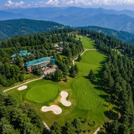 Aerial view of Naldehra Golf Course surrounded by deodar forests and Himalayan hills, featured in the Shimla Tour Package from Delhi.