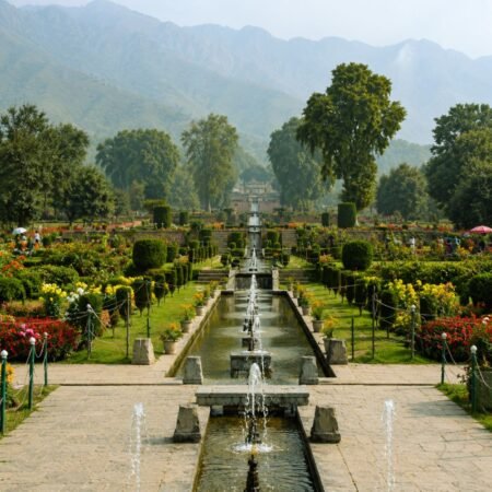 Beautiful Mughal Garden in Srinagar Kashmir with fountains, colorful flower beds and Himalayan mountains in the background