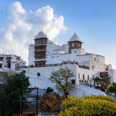 Sajjangarh Monsoon Palace in Udaipur, Rajasthan, overlooking the Aravalli Hills under a clear blue sky