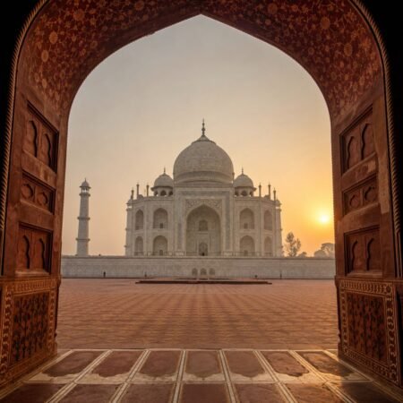 Scenic view of the Taj Mahal framed through a historic Mughal archway at sunrise in Agra, featured in the Agra Tour Package from Delhi.