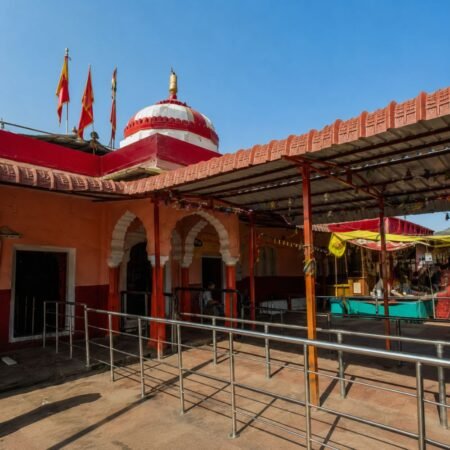 Exterior view of Trinetra Ganesh Temple inside Ranthambore Fort with its red-and-white dome, prayer flags, and temple courtyard in Sawai Madhopur, Rajasthan.
