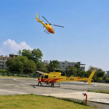 Yellow helicopter at a helipad with another helicopter flying overhead in the Himalayan region