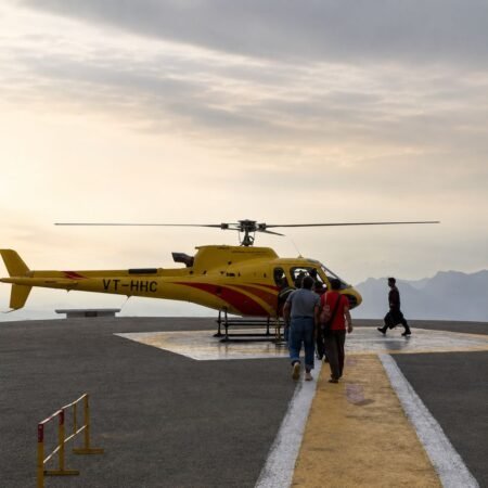 Helicopter at a mountain helipad with passengers preparing for a Kedarnath helicopter Yatra