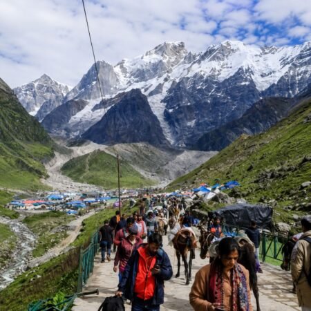 Kedarnath trek route with pilgrims, horses, mountain trail and snow-covered Himalayan peaks